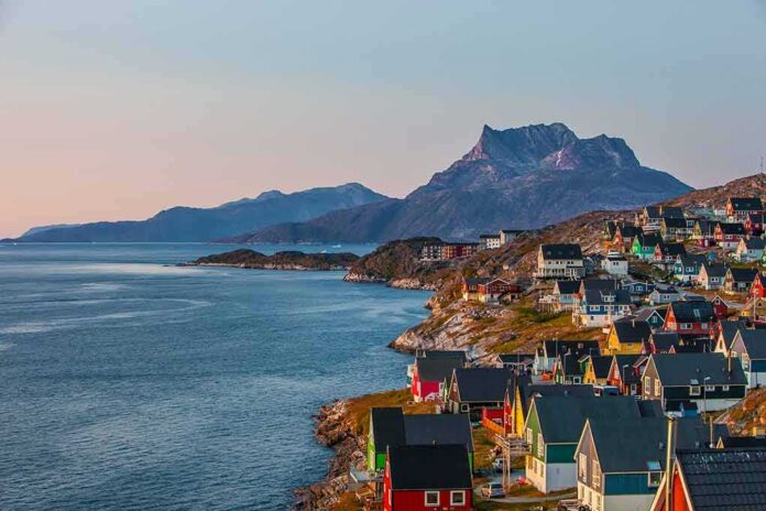 shutterstock_1484319500 Colorful coastal town with mountains and sea at sunset