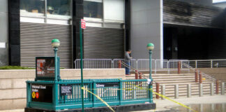 Subway entrance beside flooded street with caution tape