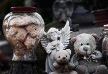 Gaza High-Rise Crumbles – Midnight Collapse Buries Sleeping Families Stuffed teddy bears and an angel figurine on a stone surface