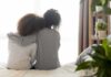 Massive Health Code Overhaul Drops ‘Mother’ Two people sitting on a bed with arms around each other