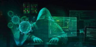 Hooded hacker at computer with digital virus graphics