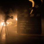 Micro-Dramas Explode – Beijing Greenlights All-AI Film Pipeline Film camera and clapperboard in smoky dramatic lighting