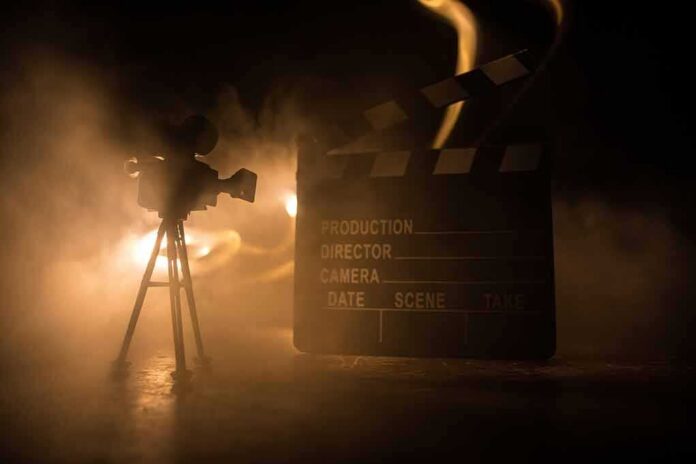 shutterstock_1733585750-1 Film camera and clapperboard in smoky dramatic lighting
