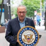 man speaking at a podium with a United States Senate seal
