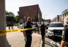 Shots Fired—Officer Down In Montreal Police officers secure an urban street with yellow tape near patrol cars