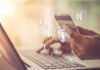 Hands holding a credit card over a laptop for online shopping