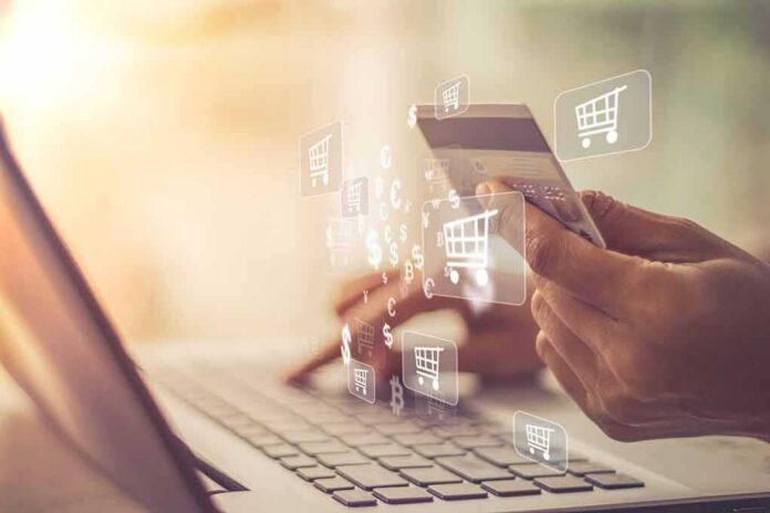 Hands holding a credit card over a laptop for online shopping