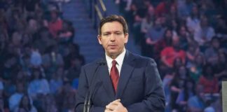 man in suit speaking at a podium