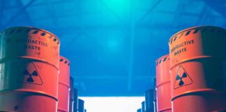Radioactive waste barrels stacked in rows inside a facility