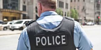 Police officer in uniform from behind on a city street