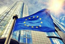 Leadership Chaos – Control Fight Wrecks Flagship Fighter European Union flag waving in front of modern glass office buildings
