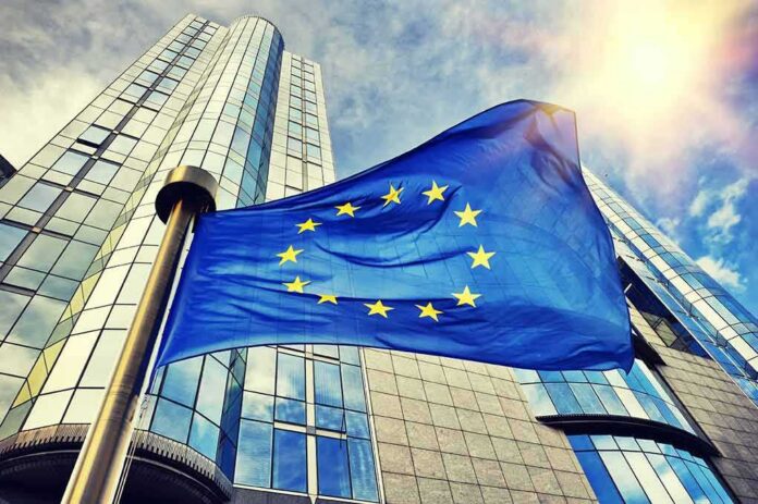 European Union flag waving in front of modern glass office buildings