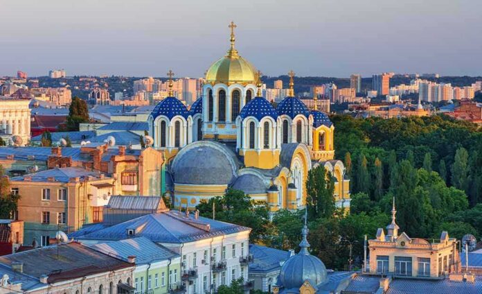 shutterstock_339128045 Orthodox church with blue and gold domes in a cityscape at sunset