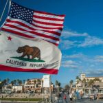 ‘Boneheaded’ Moment Haunts Newsom California Republic flag and US flag over a sunny coastal boardwalk