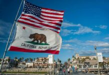 ‘Boneheaded’ Moment Haunts Newsom California Republic flag and US flag over a sunny coastal boardwalk