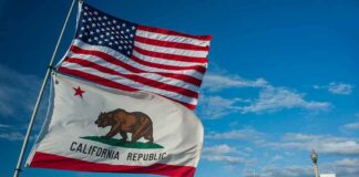 California Republic flag and US flag over a sunny coastal boardwalk