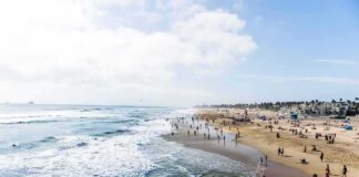 Crowded sandy beach with people by the shoreline