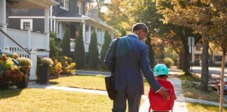 Man walking with child on sidewalk