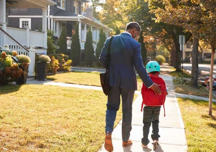 shutterstock_792014842 Man walking with child on sidewalk