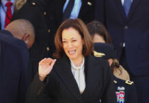 Kamala Harris waving in a crowd at a formal event
