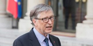 Bill Gates speaking outdoors in a suit and tie