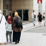 Three people walking on a city sidewalk