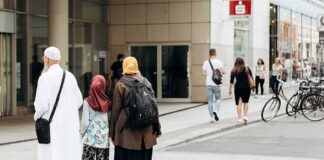 Three people walking on a city sidewalk