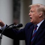 Donald Trump speaking at a podium and pointing