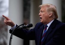 Donald Trump speaking at a podium and pointing