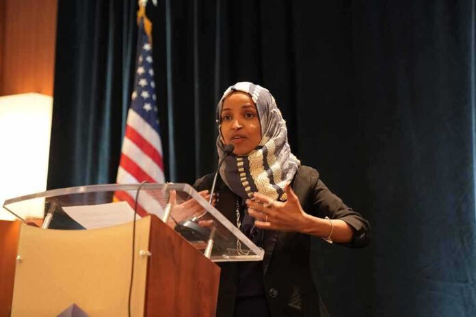 shutterstock_1311568823 Ilhan Omar speaking at a podium with a microphone