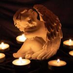 Massacre On Perry Street – Pregnant Mom, Kids Among Dead angel statue surrounded by lit candles