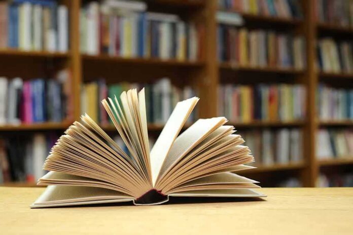 shutterstock_1889457781 Open book on a table in a library