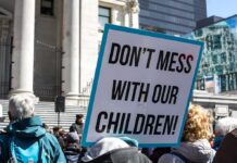 Parents Flagged: Federal Overreach Exposed protest sign held in a crowd outside a government building