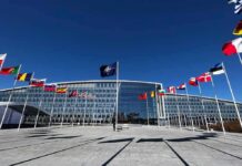 Sirens, Shelters, Stockpiles: Poland Goes Big NATO headquarters with member flags in front under a clear blue sky