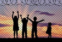Starvation Zone Emerges Under Russian Rule Children silhouetted against a chain-link fence at sunset