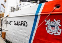 Packed Boat Snagged – Dangerous Caribbean Crossing Stopped Cold US Coast Guard ship hull with emblem and red stripe