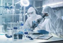 Russia Goes Dark After Lab Fatality Scientists in protective suits using a microscope in a laboratory